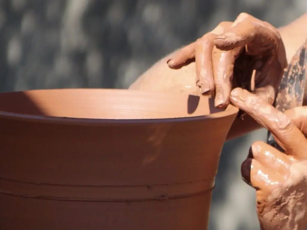 Photo de mains de potier en train de former un pot d'argile, représentant l'association Terre de Saint Jean.
